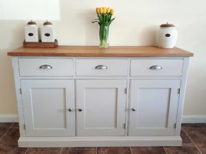 Edmunds Painted 5ft Sideboard handmade from Edmunds & Clarke Furniture. Painted in Dunwich stone with a solid square oak top, 3 drawers and 3 doors, image showing cup chrome cup handles and chrome knobs EDM029