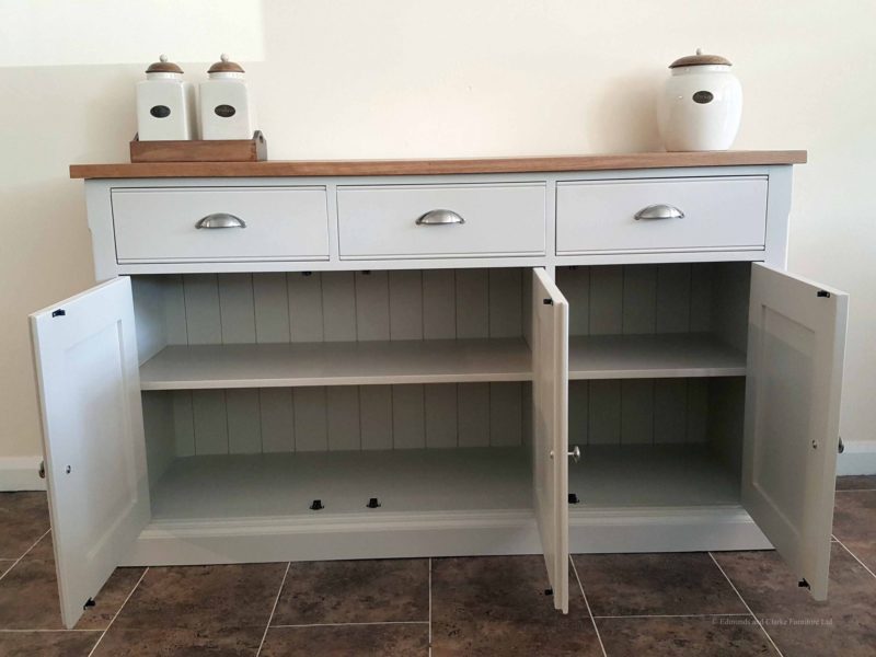 5ft Painted Sideboard handmade from Edmunds & Clarke Furniture. Painted in Dunwich stone with a solid square oak top, 3 drawers and 3 doors, image showing doors open with cup chrome cup handles and chrome knobs EDM029