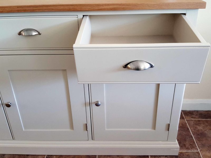 5ft Painted Sideboard handmade from Edmunds & Clarke Furniture. Painted in Dunwich stone with a solid square oak top, 3 drawers and 3 doors, image showing drw open with cup chrome cup handles and chrome knobs on doors. EDM029