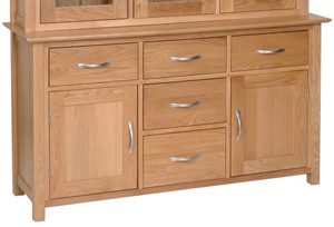 Norwich Oak 4'6 Dresser Base. Contemporary shaker style with clean lines. moulded top. chrome shaped bar handle. 1 adjustable shelf inside 2 cupboards and 5 handy drawers above. Sits with Norwich oak 135cm dresser top. NNS20