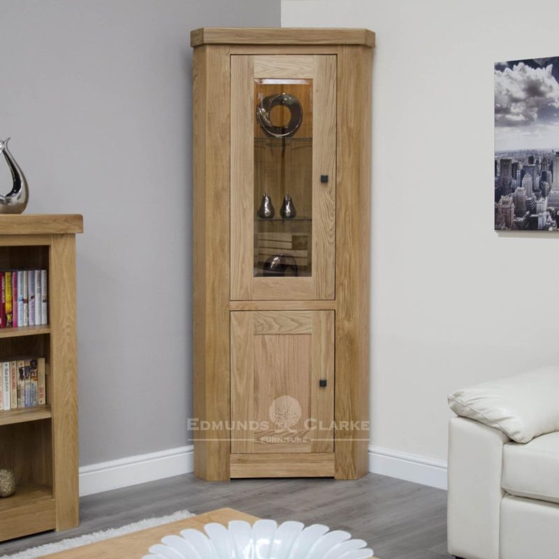 Hadleigh solid oak chunky corner display unit & light. Light lacquered finish with LEd light, Square rustic handles and adjustable glass shelves in the top part.