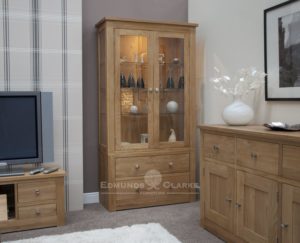 solid oak glass sided display cabinet with lights and glass shelves, two drawers below