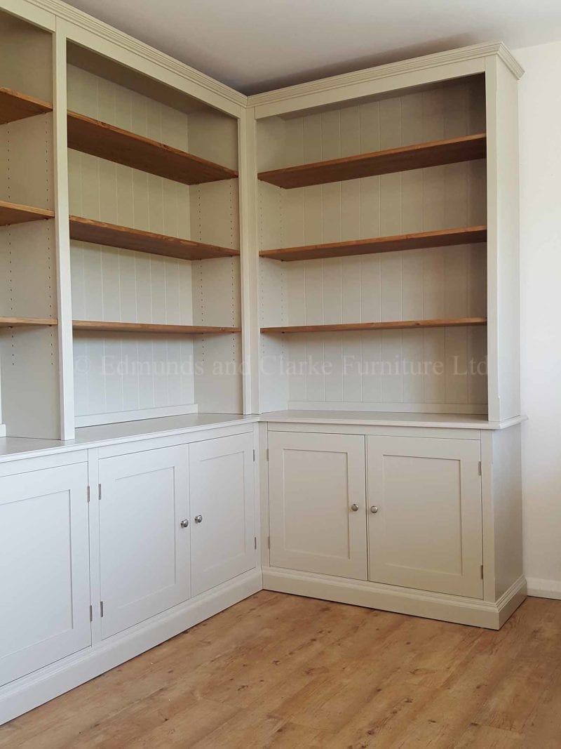 Corner library bookcase painted with wooden waxed shelves, cupboards below