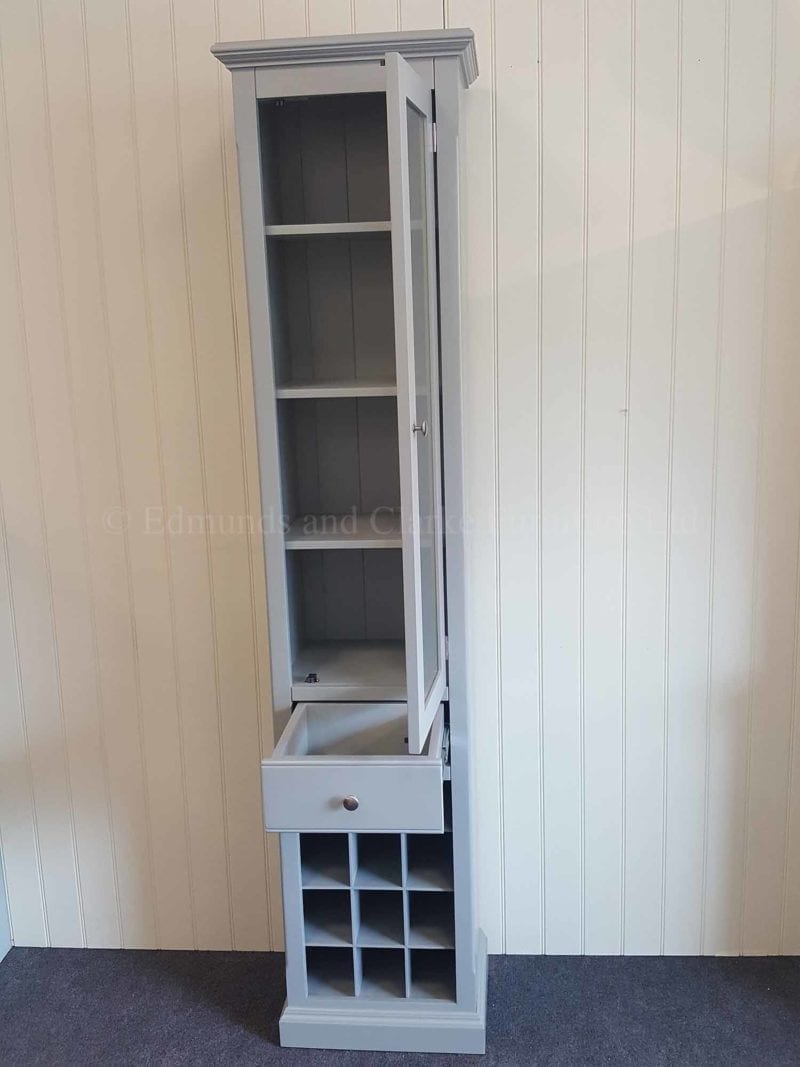 Tall narrow glazed cupboard with drawer and wine rack below