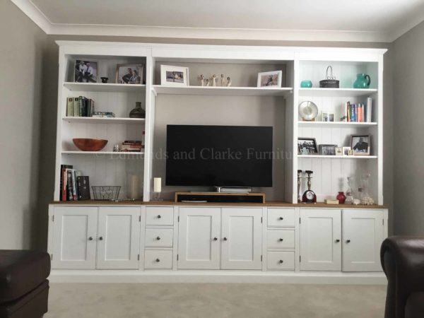 large wide tv storage solution with shelving and cupboards painted white