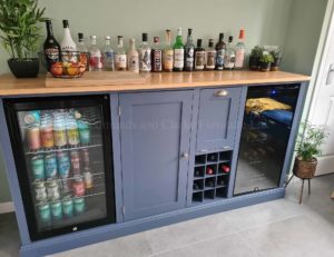 Sideboard housing beer and wine cooler with wine rack and useful cupboard storage painted with solid oak top